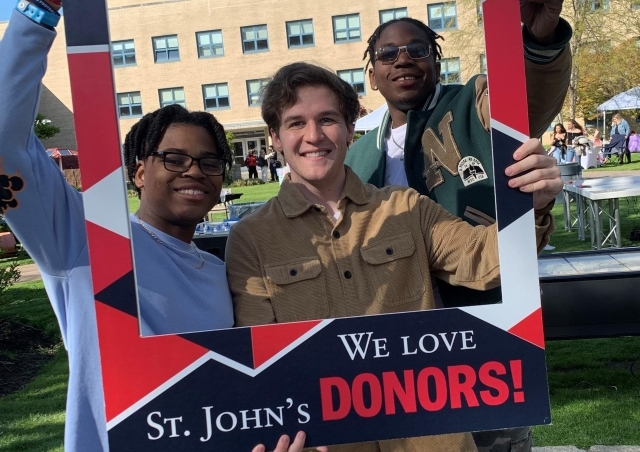 St. John's Student holding a Thank You poster