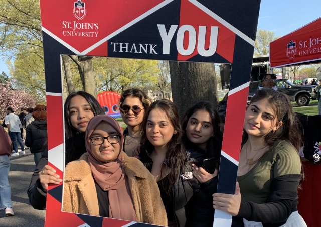 St. John's Student holding a Thank You poster